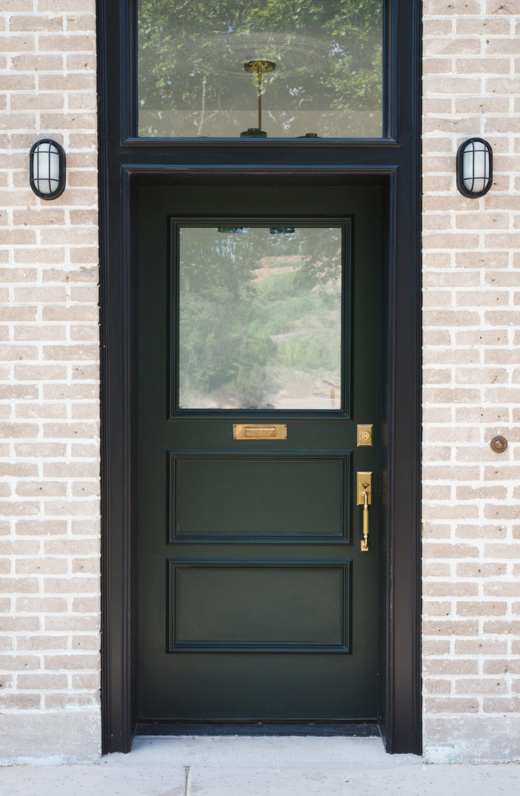 Dark green door with black casing and vintage brass door knob and hardware. This post has great sources for antique style hardware!!