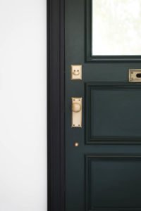 Dark green door with black casing and vintage brass hardware. Great Sources for hardware!!